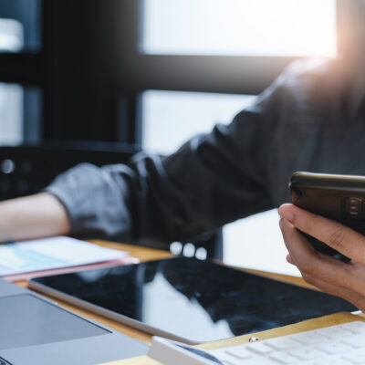 Business woman hand holding pen and cell phone with bank savings account application, account or saving money or insurance concept. Business woman hand holding pen and cell phone with bank savings account application, account or saving money or insurance concept